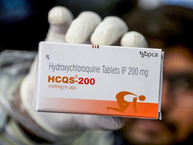 This photo taken on April 28, 2020 shows a pharmacist displaying a box of hydroxychloroquine (HCQ) tablets in his store in Hyderabad. - India has ramped up output of an anti-malarial drug hailed by US President Donald Trump as a "game-changer" in the fight against coronavirus, even as its pharmaceutical industry struggles to make other key medicines in a lockdown. (Photo by NOAH SEELAM / AFP) / TO GO WITH AFP STORY health-virus-India-pharmaceutical by Bhuvan Bagga and Vishal Manve