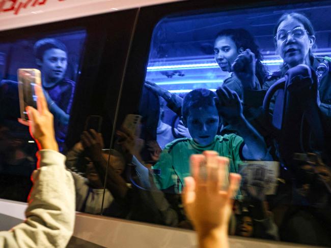 Hostages released by Hamas wave to the crowd from a vehicle driving towards an army base in Ofakim on November 26, 2023 after they were released by Hamas from the Gaza Strip. Israel's prison service said 39 Palestinian detainees were released on November 26, 2023 under the terms of a truce agreement between Israel and Hamas in the Gaza Strip. The announcement came after 13 Israeli hostages were freed in the Palestinian territory under the deal, along with three Thais and a Russian-Israeli dual citizen. (Photo by Menahem KAHANA / AFP)