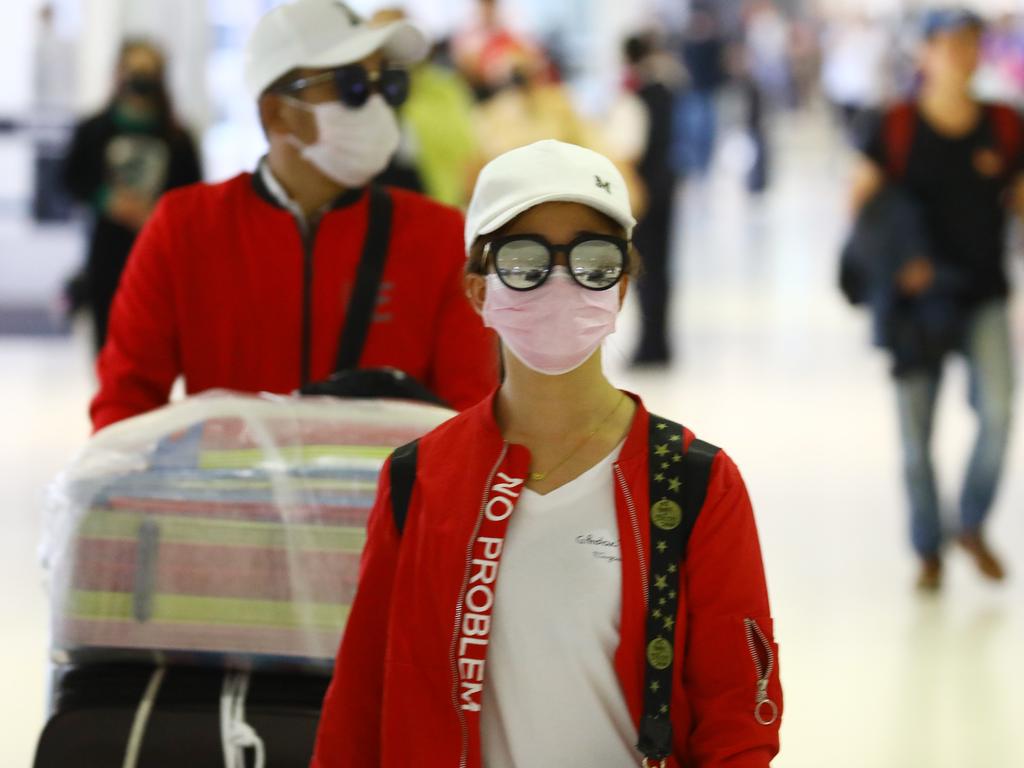 Passengers at Sydney Airport taking precautions against the virus. Picture: Matrix Pictures