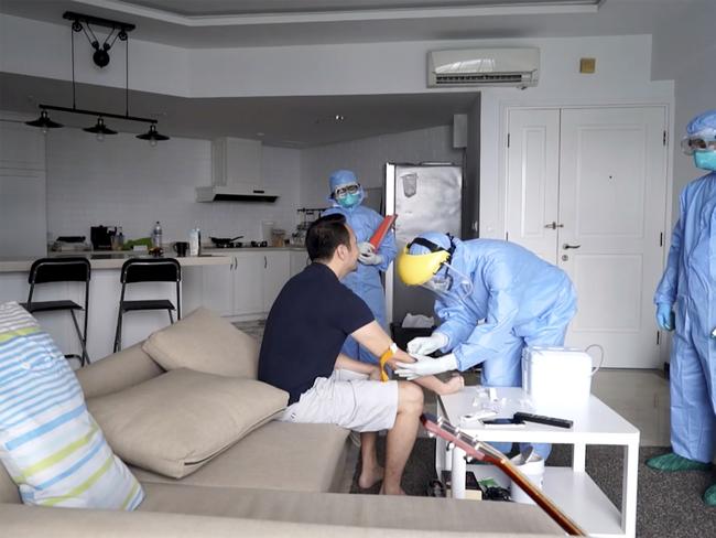 In this image from a video, an Indonesian local health service personnel extracts blood from an individual on self-quarantine, as they conduct a COVID-19 rapid test in Jakarta. Picture: AP