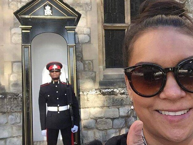 Gold Coast Suns general manager of people and organisation development Megan Green poses in front of a royal guard.