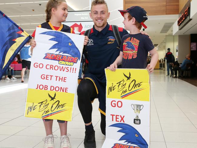 Crows’ Hugh Greenwood with young fans Olivia and William Abbott at Adelaide Airport before flying for Melbourne. Photo: Calum Robertson