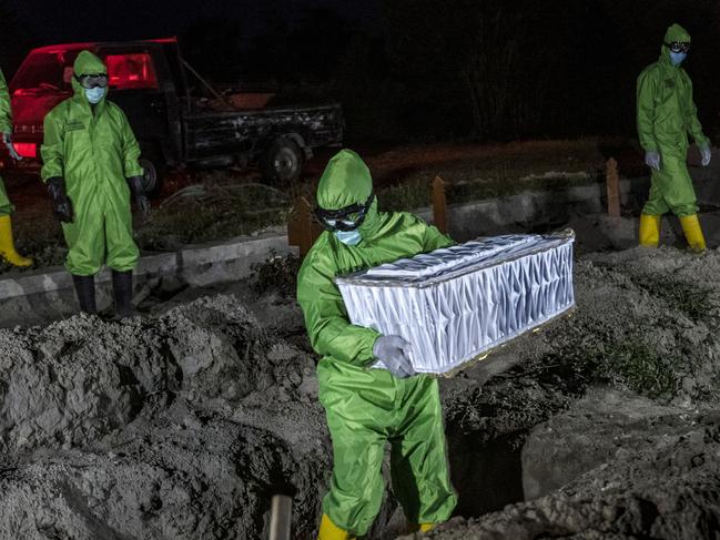 A worker carries a coffin containing a baby that died in the womb after the mother contracted Covid-19. Picture: AFP