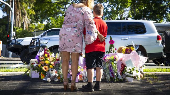 People pay tribute at the scene in Alexandra Hills where Matty Field and Kate Leadbetter were killed by an out-of-control car while walking their dog. Picture: NIGEL HALLETT