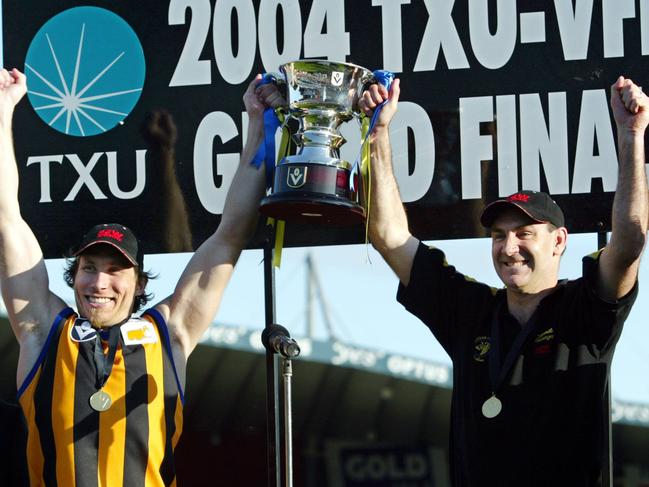 Captain Chad Liddell and coach Mark Williams lift the 2004 premiership cup.