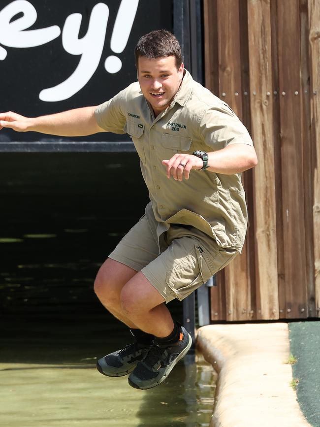 Chandler Powell helps feed a crocodile at Australia Zoo.