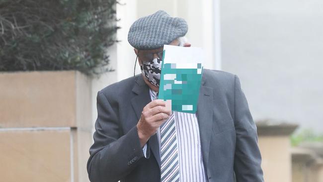 Convicted paedophile John Wayne Millwood tries to conceal his face from cameras as he enters the Federal Court at Hobart. Picture: Nikki Davis-Jones