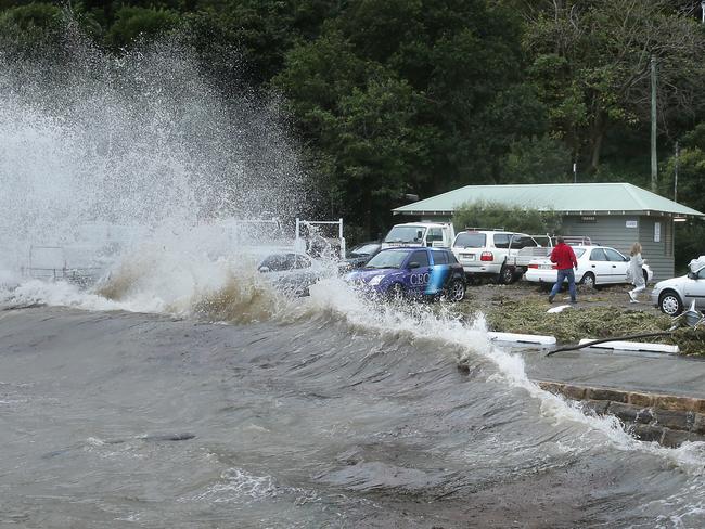 People run after an unexpected wave hits Palm beach wharf.