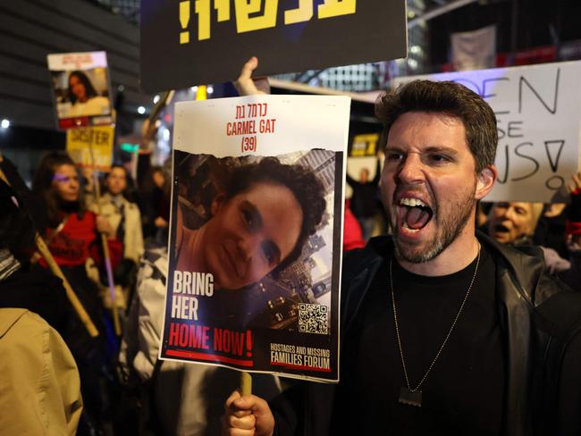 \ A man holds a placard bearing the portrait of Israeli hostage Carmel Gat as Hamas says hostages in Gaza are “struggling to survive”. Picture: AFP