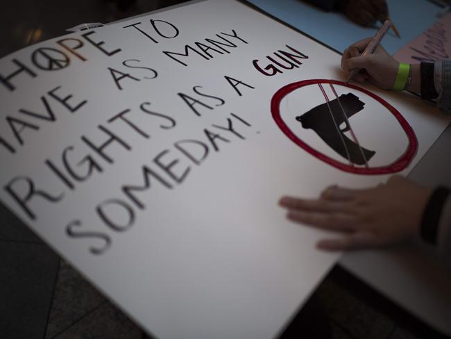 Activists, schoolchildren and students prepare posters and slogans on the eve of the "March for our lives" rally in Washington. Picture: AFP