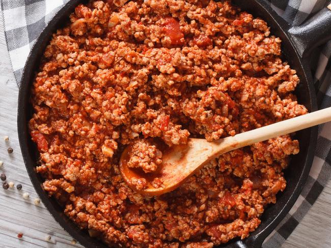 Bolognese sauce in a frying pan close-up on the table. horizontal view from above Picture: Istock