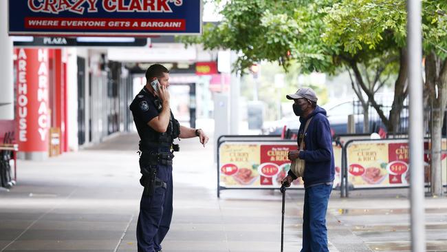 A police officer talks to an indigenous man about the lockdown rules in Cairns. Picture: Brendan Radke