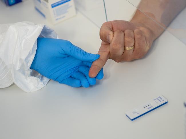 A health worker wears a protective mask and suit as she extracts blood from a patient to perform an antibody test for COVID-19. Picture: Getty Images