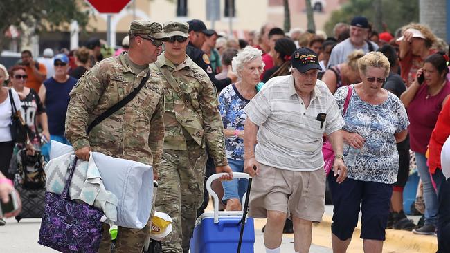 US national guardsmen help the elderly find shelter at Estero, Florida.