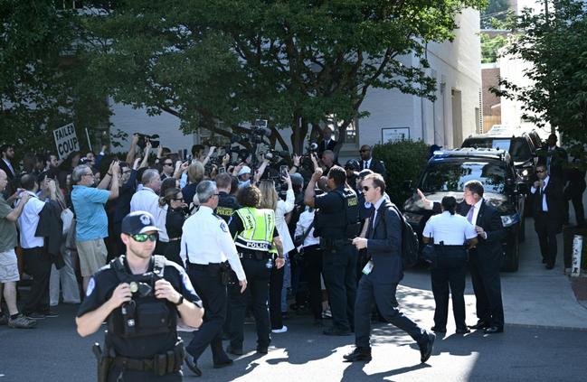 US Capitol police officers hold back media and protesters as former US president Donald Trump arrives for a meeting with US House Republicans on June 13, 2024