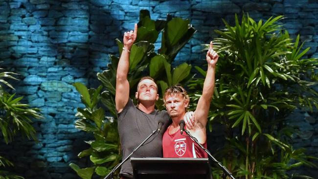 Ruben McDornan (left), who was the sole survivor of the sunken trawler MV Dianne points to the sky with second skipper Adam Kelly (right) at the memorial service for the lost crew members in Cairns. (AAP Image/Darren England)