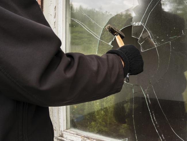 Burglar entering to house trough window - Picture istock