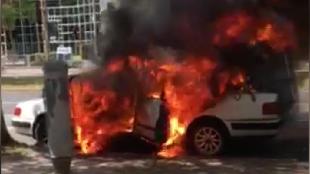 A car burns on St Kilda road