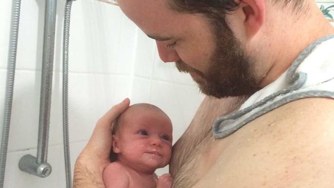 Journalist Owen Jacques holding his daughter during her first shower. Picture: Contributed