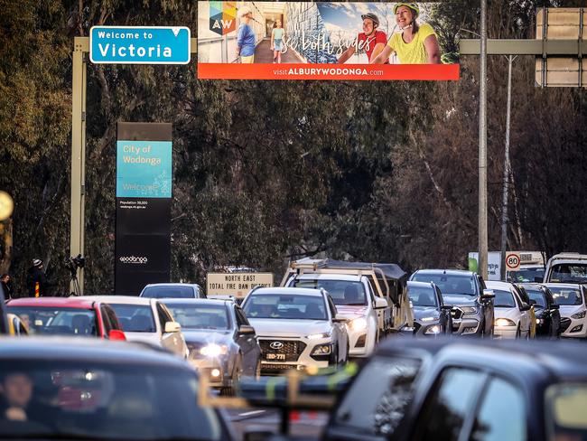 Cars sit in a line near a police checkpoint in Albury, Australia. NSW residents returning from Victoria will need to self isolate for 14 days, while Victorian residents are banned from travelling to NSW unless they have a permit. Picture: Getty