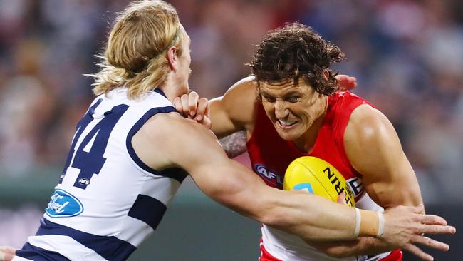 Sydney's Kurt Tippett tries to break the tackle of Geelong's Corey Enright.  