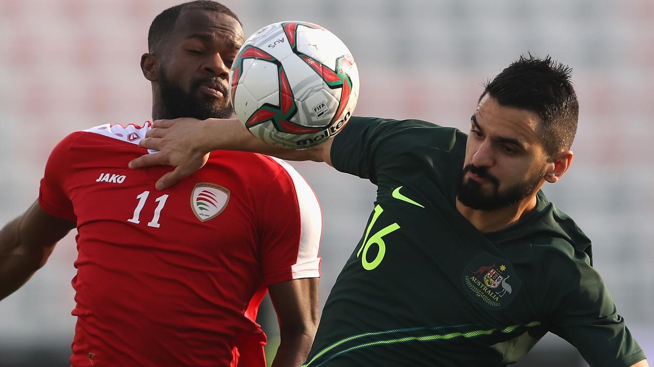 Aziz Behich muscles his way through the Omani defence.