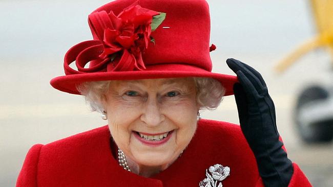 Queen Elizabeth II holds on to her hat in high winds as she arrives for a visit to RAF Valley in Anglesey, Wales on April 1, 2011. AFP PHOTO / Christopher Furlong /WPA POOL (Photo by Christopher Furlong / POOL / AFP)