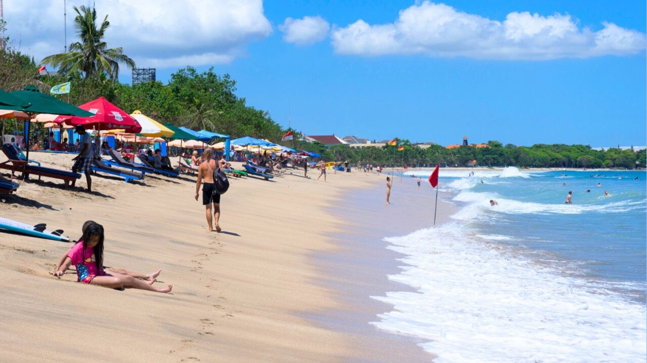 People relax on a beach in Kuta. Picture: Supplied