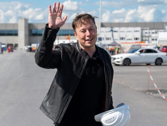 Tesla CEO Elon Musk poses for a photo with a hard hat at the construction site for the new plant, the so-called "Giga Factory", of US electric carmaker Tesla in Gruenheide near Berlin, northeastern Germany. - The site still has only provisional construction permits, but Tesla has been authorised by local officials to begin work at its own risk. Tesla is aiming to produce 500,000 electric vehicles a year at the plant, which will also be home to "the largest battery factory in the world", according to group boss Elon Musk. (Photo by Christophe Gateau / dpa / AFP) / Germany OUT