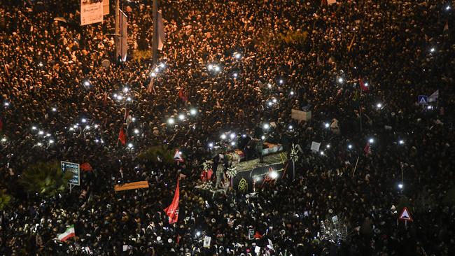 Mourners surround a truck carrying the flag draped coffins of Gen. Qassem Soleimani and his comrades in the holy city of Qom. Picture: AP.