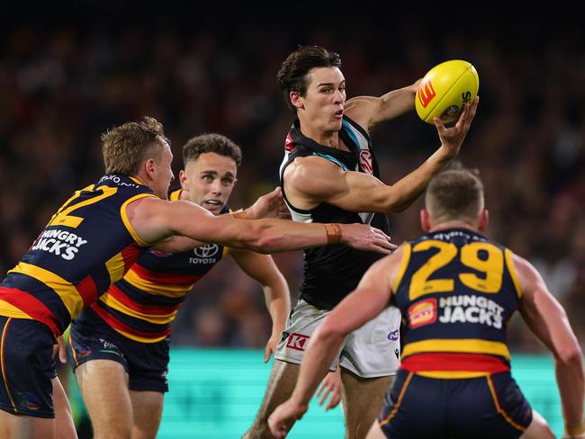 Connor Roze handballs against the Crows. Picture: Sarah Reed/AFL Photos via Getty Images