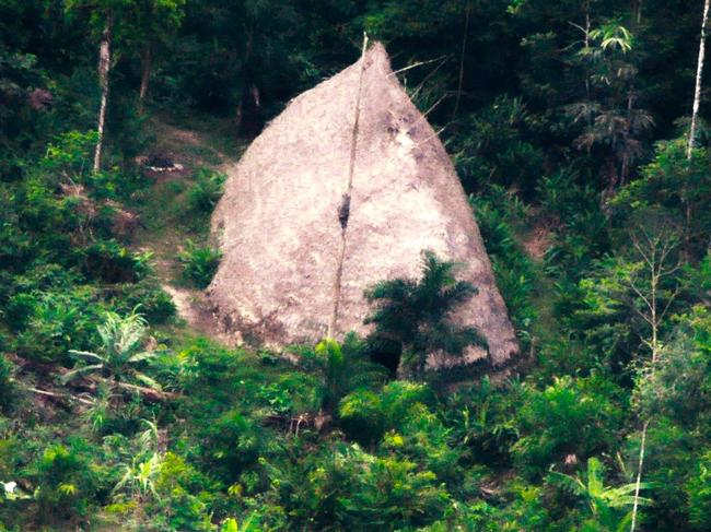 Handout drone picture taken in 2017 released by the Brazilian government body FUNAI (National Indian Foundation) on August 23, 2018, showing a thatched hut in the indigenous territory Vale do Javari in the Brazilian Amazon forest in the State of Amazonas, near the border with Peru. - Video and still images released by FUNAI taken in 2017 and 2018 show members of an isolated tribe walking through a clear in the jungle, canoes, axes and a thatched hut. (Photo by Adam MOL / National Indian Foundation / AFP) / RESTRICTED TO EDITORIAL USE - MANDATORY CREDIT "AFP PHOTO / FUNAI / ADAM MOL" - NO MARKETING NO ADVERTISING CAMPAIGNS - DISTRIBUTED AS A SERVICE TO CLIENTS