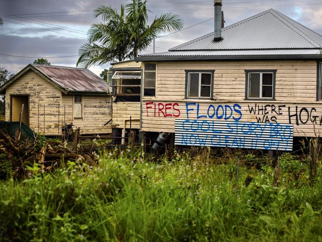 This photo taken on May 15, 2022, shows houses with political graffitis after the recent floods devastation in the New South Wales town of Lismore. - Two months since an unprecedented flood, thousands of residents remain homeless and are struggling to recover. (Photo by Patrick HAMILTON / AFP) / TO GO WITH: Australia-vote-climate-flood, FOCUS by Maddison Connaughton