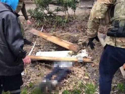 Footage shows a mother showing Ukrainian troops her daughter's shallow grave. Credit: Twitter