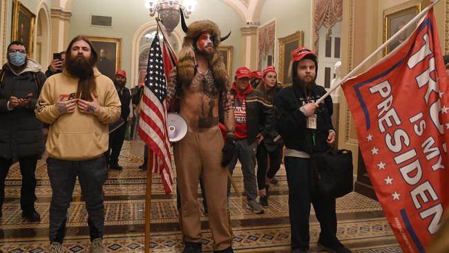 QAnon member Jake Angeli, aka Yellowstone Wolf, centre, in the US Capitol on January 6. Q believers took up Donald Trump’s cry that last year’s US election had been stolen. Picture: AFP