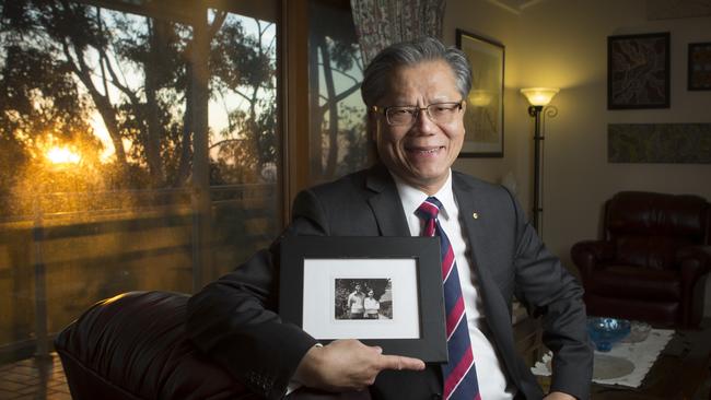 Hieu Van Le holds a photograph of himself and his wife Lan Le.