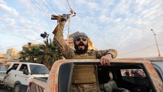 A triumphant Syrian anti-government fighter cheers as he enters Hama. Picture: AFP