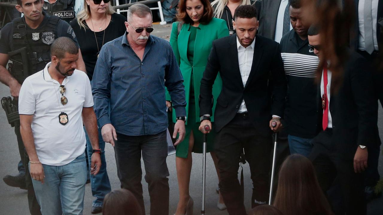 Neymar arrives on crutches at the Women's Defence Precinct in Sao Paulo