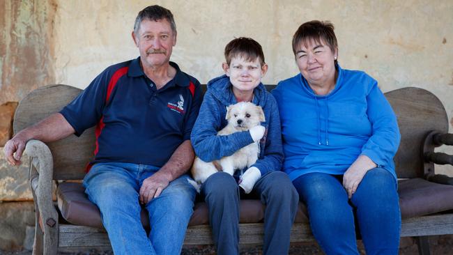 John and pooch Penny with Neville and Therese Busch, who are his guardians. They have a daily battle dealing with EB. Picture Matt Turner.