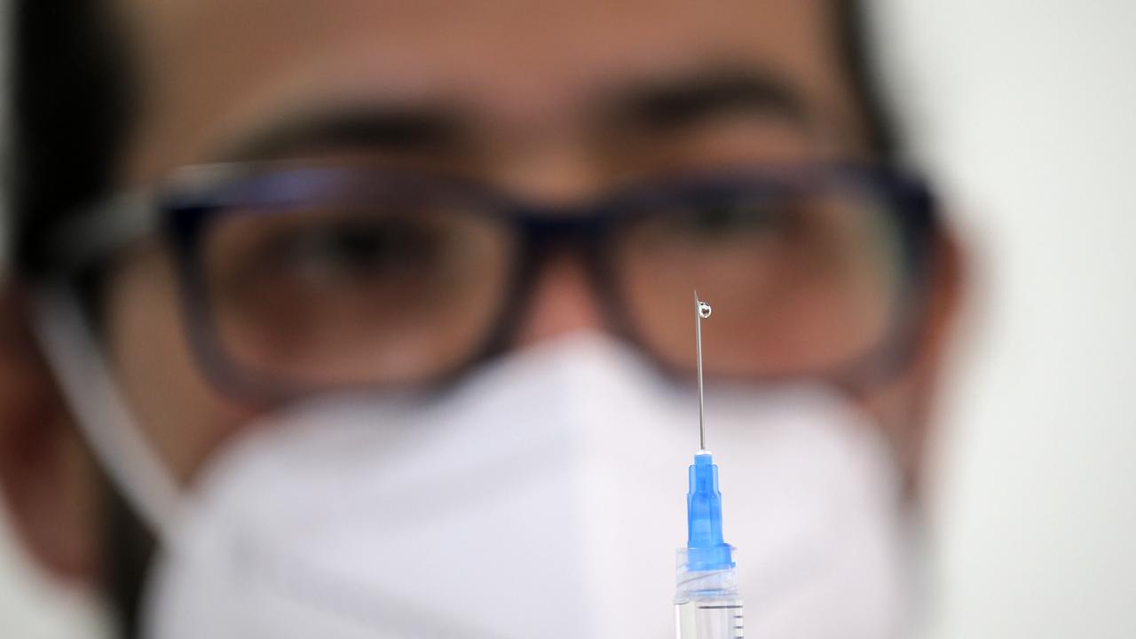 A health workers fills a syringe with a dose of the Pfizer-BioNTech vaccine against COVID-19 at a vaccination centre on July 12, 2021. (Photo by JAVIER TORRES / AFP)