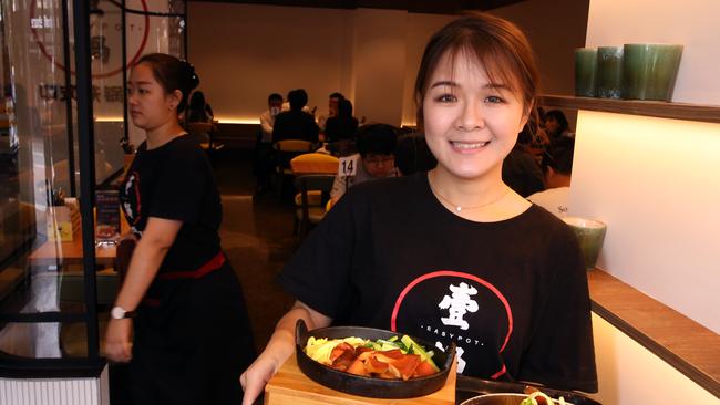 Staff member Lin Ling serves up the vegetable salad and stewed beef brisket. Picture: Stuart Milligan