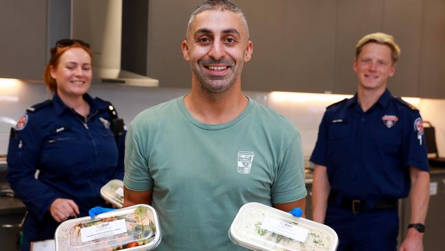 Sam Georges dispenses such lunch to paramedics Jessie Fraser and Jordan Rosser. Picture: Angelo Velardo