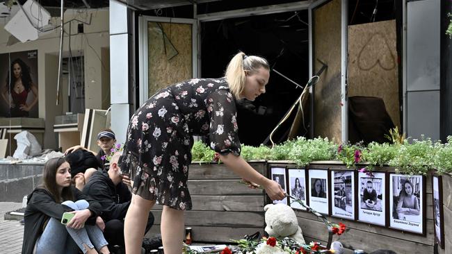 A woman lays a flower at a restaurant destroyed in a recent missile strike, in the centre of Kramatorsk. Twelve people died in the June 29 strike, including children. Picture: Getty