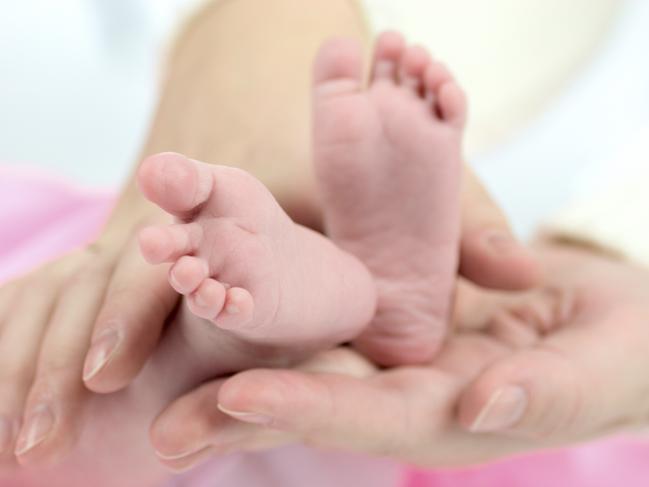 Generic photo illustrating IVF. Mother's hands holding Baby's tiny feet. Picture: iStock