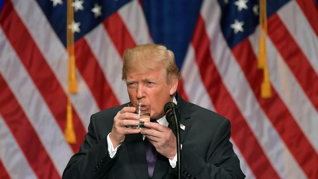 TOPSHOT - US President Donald Trump takes a drink of water as he speaks about his administration's National Security Strategy at the Ronald Reagan Building and International Trade Center in Washington, DC, December 18, 2017. President Donald Trump rolled out his first "National Security Strategy", a combative document designed to put meat on the bones of his "America First" sloganeering. / AFP PHOTO / MANDEL NGAN