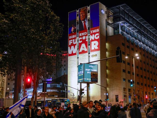 A billboard calling for an end of the war between Israel and Hamas along with a portrait of US President-elect Donald Trump stands on top of a building in Jerusalem. Picture: AFP