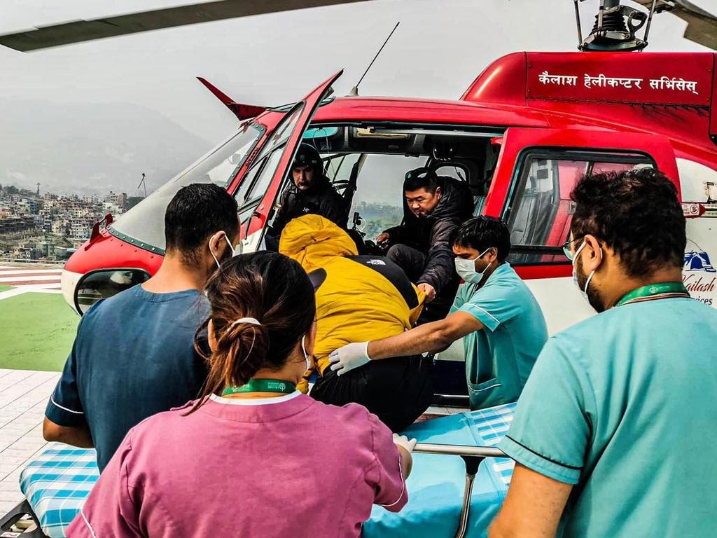 Global Rescue’s David Koo preparing for an airborne rescue (Koo is inside the chopper assisting a patient).