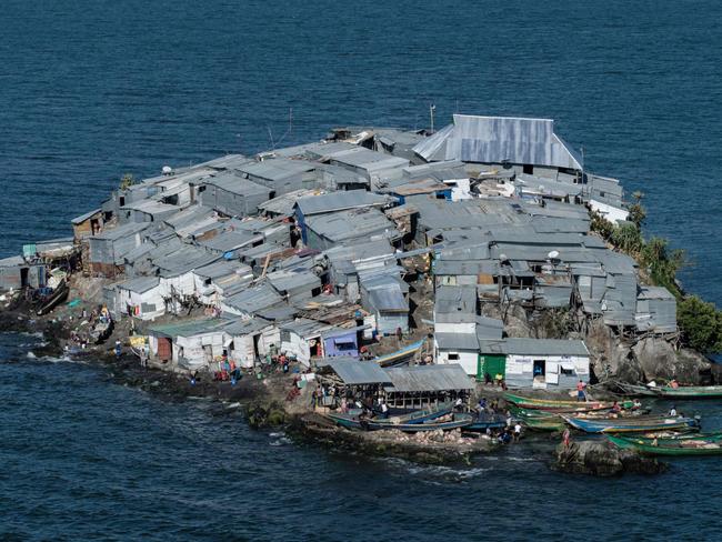 A picture taken on October 5, 2018, shows a general view of Migingo island which is densely populated by residents fishing mainly for Nile perch in Lake Victoria on the border of Uganda and Kenya. - A rounded rocky outcrop covered in metallic shacks, Migingo Island rises out of the waters of Lake Victoria like an iron-plated turtle. The densely-populated island is barely a quarter of a hectare large, its residents crammed into a hodge-podge of corrugated-iron homes, with seemingly little but a few bars, brothels and a tiny port to boast of. (Photo by Yasuyoshi CHIBA / AFP)