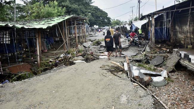 Residents walk past a damaged area after heavy rains and strong winds lashed East Timor's capital Dili overnight causing extensive flooding on April 4, 2021. Picture: VALENTINO DARIEL SOUSA / AFP