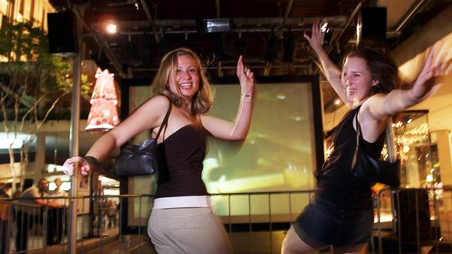 31 Dec 2003 - Anna Vecchio, /Birkdale, and Claire Collone, /Balmoral - New Year's Eve revellers dance in the Queen St Mall Brisbane. PicAndrew/Maccoll. celebrations